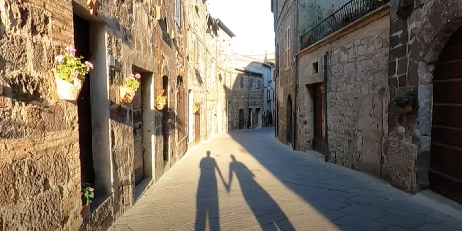 A sunlit stone lane in an Italian hill town on the Way of St Francis